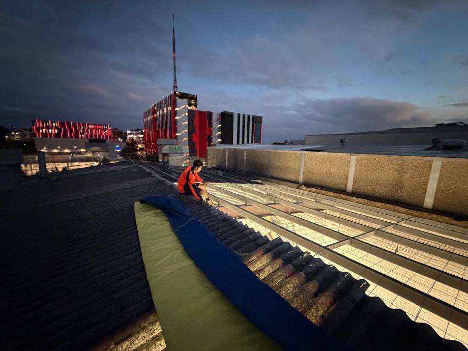 Asbestos roof tarped down and made weather-tight at dusk on the Artarmon job