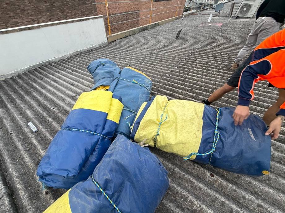 Removed asbestos sheeting double-wrapped and bundled on the Artarmon roof