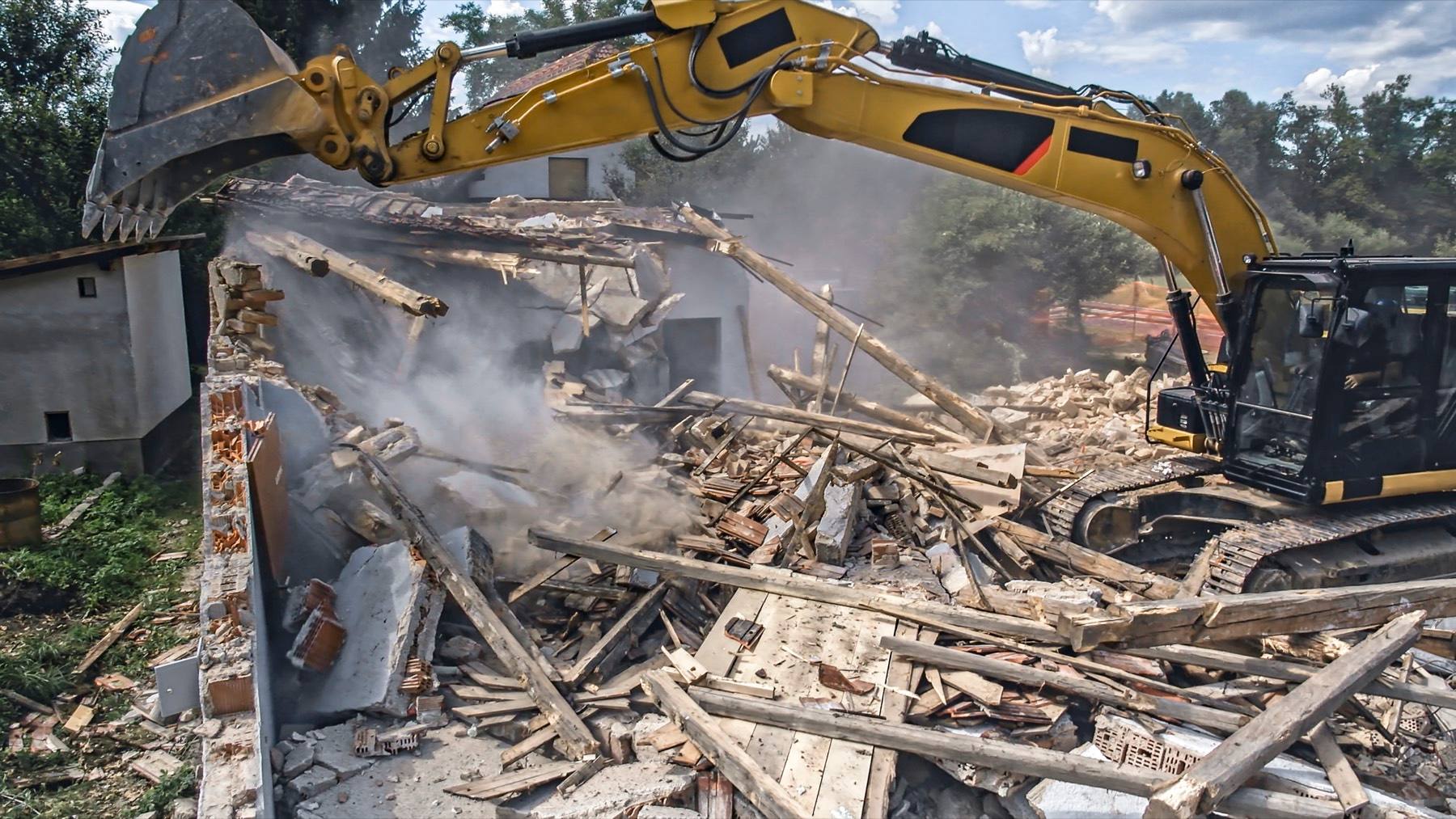 Excavator demolishing a house during a knockdown