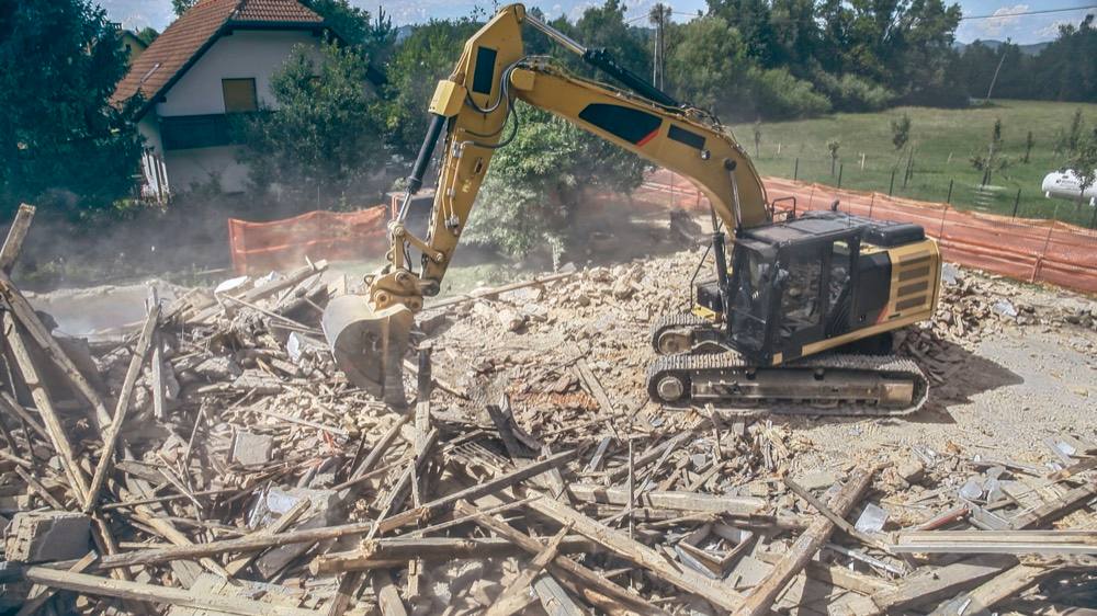 Excavator demolishing a house during a knockdown