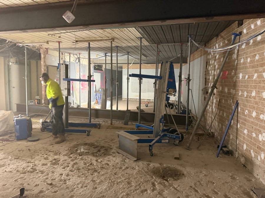 HazWreck crew stripping out the World Gym space with the ceiling propped