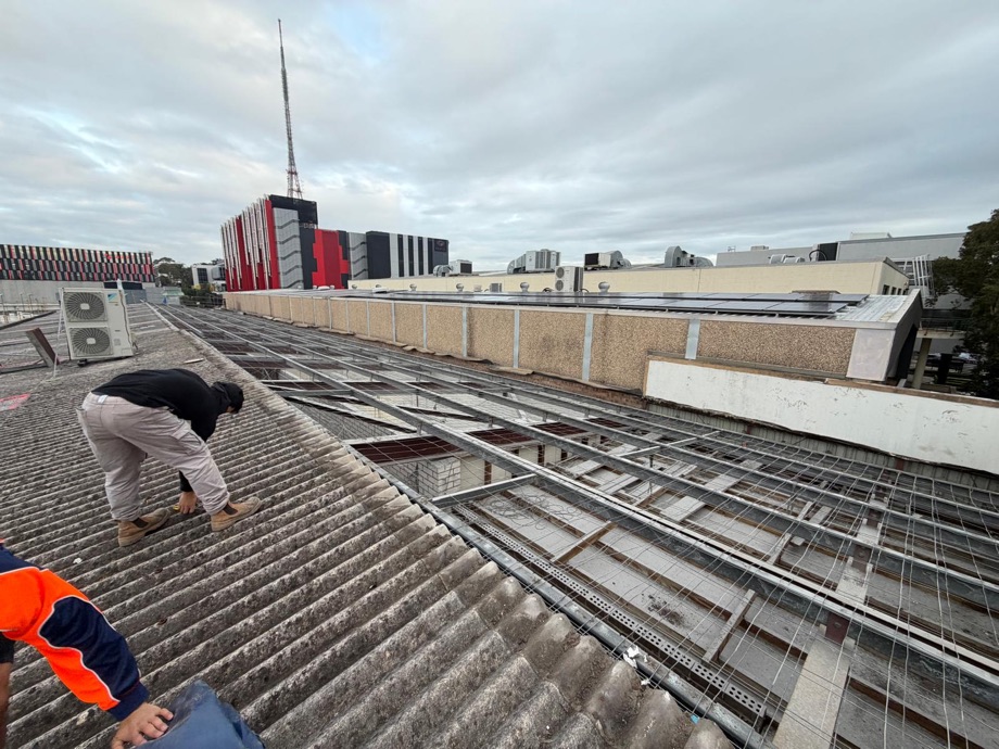 HazWreck crew member removing bonded asbestos roof sheeting by hand in Artarmon