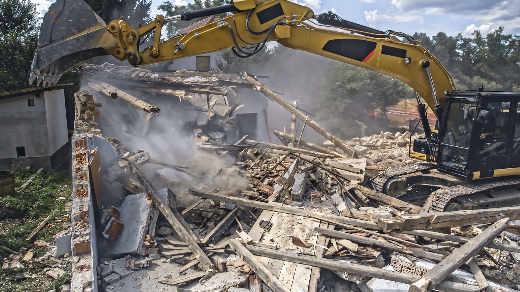 Excavator demolishing a house during a knockdown