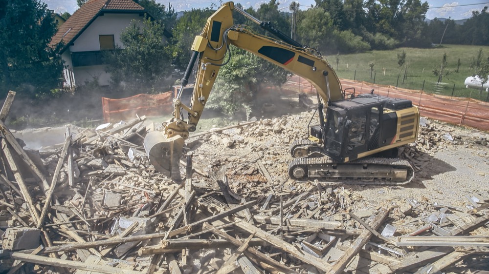 Excavator demolishing a house during a knockdown